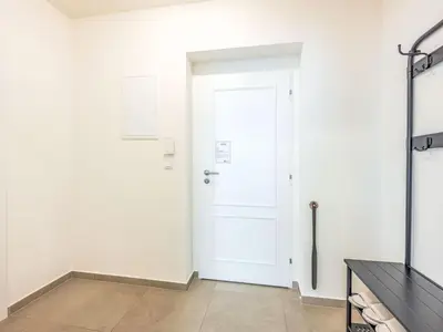 a room with a white door and a television at Apartment Čelakovsky-1 by Interhome in Prague