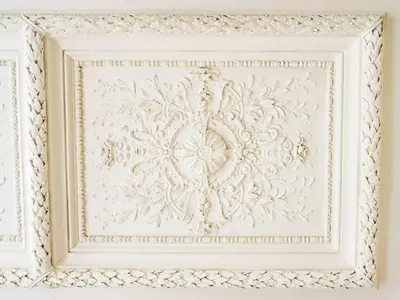 a white picture frame on a wall with a patterned ceiling at Apartment Nekazanka by Interhome in Prague