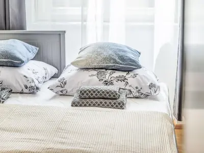 a bed with four pillows on top of it at Apartment Nekazanka by Interhome in Prague