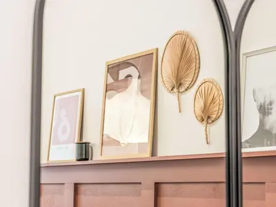 a shelf with framed pictures and a mirror at Apartment Čelakovsky-2 by Interhome in Prague