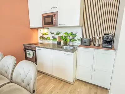 a small kitchen with white cabinets and a microwave at Apartment Washington-1 by Interhome in Prague