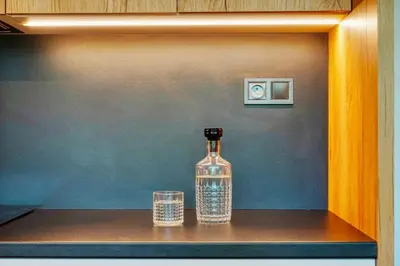 a bottle and two glasses sitting on a shelf at Carme Apartment with Parking in Prague