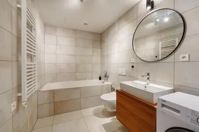 a bathroom with a tub and a sink and a mirror at Carme Apartment with Parking in Prague