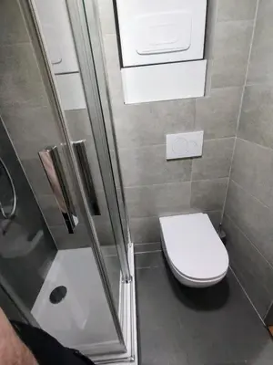 a small bathroom with a toilet and a shower at Two bedroom apartment with parking in Prague