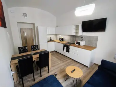 a living room with a kitchen and a table with chairs at Two bedroom apartment with parking in Prague