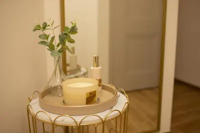 a table with a vase of flowers and a mirror at Tynska apartment in Prague