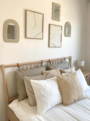 a bed with white pillows and pictures on the wall at Jack apartman , 02 Arena ,PVA Expo, Free parking in Prague