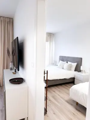 a white room with a bed and a tv on a table at Amy apartman , 02 Arena, Free parking in Prague