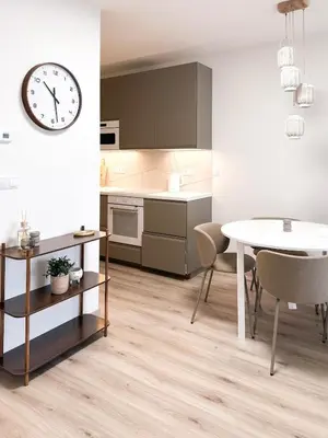 a kitchen and dining room with a table and a clock at Amy apartman , 02 Arena, Free parking in Prague
