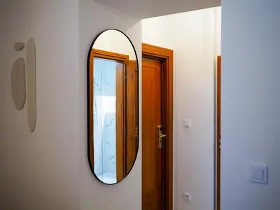 a mirror on a wall next to a door at Hotel 16 & Apartments Prague City Living in Prague