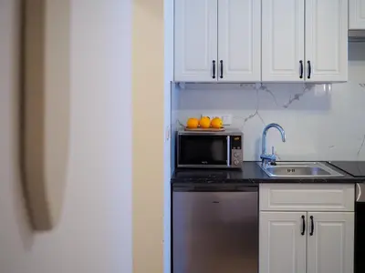 a kitchen with a microwave and oranges on a counter at Hotel 16 & Apartments Prague City Living in Prague
