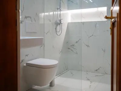 a white bathroom with a toilet and a shower at Hotel 16 & Apartments Prague City Living in Prague