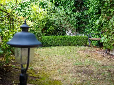 a street light in a garden with a bench at Hotel 16 & Apartments Prague City Living in Prague