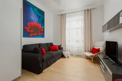 a living room with a gray couch and red pillows at Sweet Spot for 6 in Trendy Area! Family friendly! in Prague