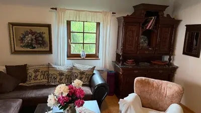 a living room with a couch and a table with flowers at Křivoklátské Johnyho bydlení in Křivoklát