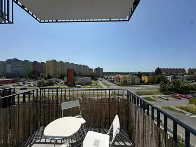 a balcony with two chairs and a table on it at Cozy Modern Apartment, 20 mins to Center in Prague