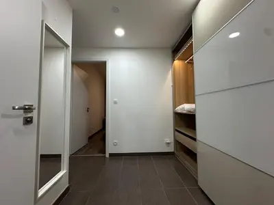 a hallway with a door leading to a room with a closet at Cozy Modern Apartment, 20 mins to Center in Prague