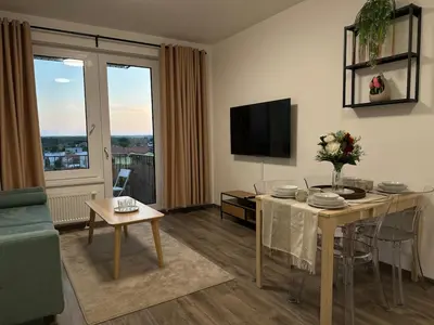 a living room with a table and a television at Cozy Modern Apartment, 20 mins to Center in Prague