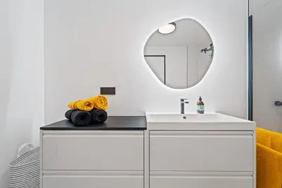 a bathroom with a white sink and a mirror at Karlín Diamond View & Garage in Prague