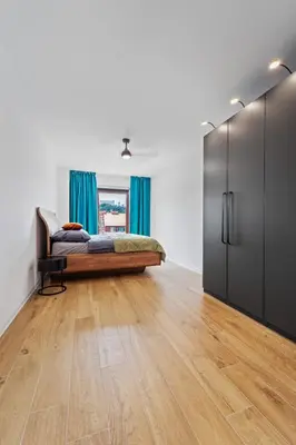 a bedroom with a bed and blue curtains at Karlín Diamond View & Garage in Prague