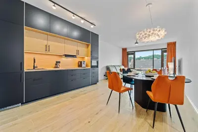 a kitchen with a dining table and orange chairs at Karlín Diamond View & Garage in Prague