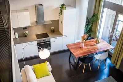 a bathroom with a tub and a sink and a washing machine at Family apartments with balcony in center of Prague in Prague