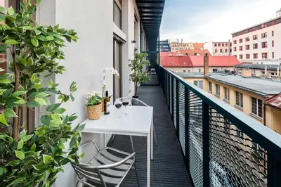 a bedroom with a large bed and a painting on the wall at Family apartments with balcony in center of Prague in Prague