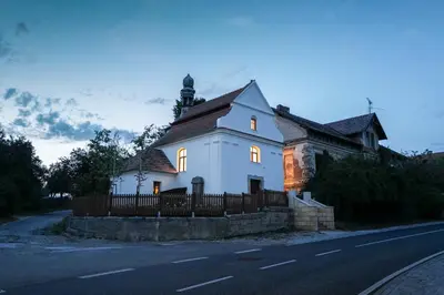 a white house with lights on the side of a road at Kaple Jinak in Vrchovany