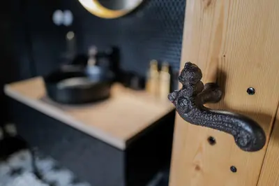 a black door knob on a wooden door with a sink at Kaple Jinak in Vrchovany