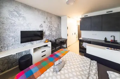 a small room with a bed and a flat screen tv at Vilda's Nest by Renka & Tom in Prague