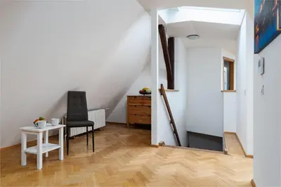 a room with a table and a chair and a staircase at Blue Sky Residence in Prague