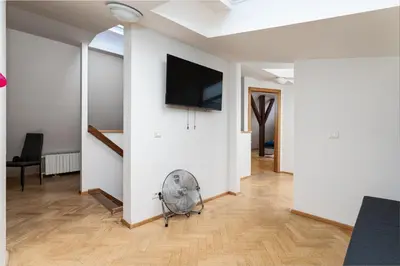 a living room with a fan and a tv on a wall at Blue Sky Residence in Prague