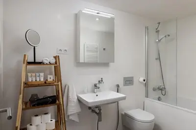a white bathroom with a sink and a toilet at Elegant Prague Flat with Balcony, Workspace, Garage in Prague