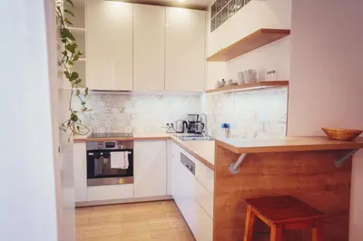 a kitchen with white cabinets and a wooden table at Family apt with Terrace, near Center, big Parks and Viewpoints in Prague