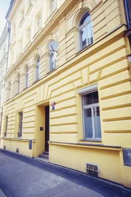 a yellow building with windows on a street at Family apt with Terrace, near Center, big Parks and Viewpoints in Prague