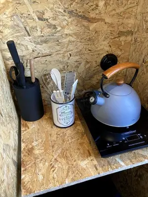 a tea pot on a stove next to a container of utensils at Escape to the Czech Republic in this Wonderful Tree House in Nature in Prague