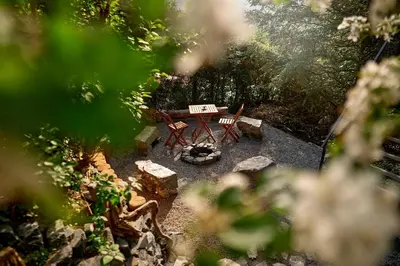 a backyard with a picnic table and a fire place at Escape to the Czech Republic in this Wonderful Tree House in Nature in Prague
