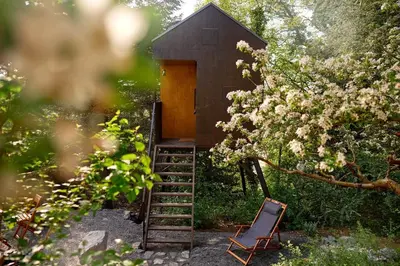 a small tree house with a ladder and a chair at Escape to the Czech Republic in this Wonderful Tree House in Nature in Prague