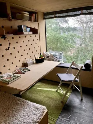 a table and a chair in a room with a window at Escape to the Czech Republic in this Wonderful Tree House in Nature in Prague