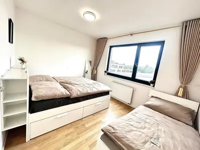 a room with a white wall and a bench at Bright Apartment - Na Vinici Prague 2 in Prague
