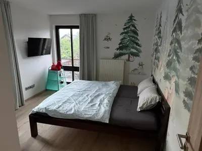 a bedroom with a bed and a christmas tree on the wall at Luxury Prague House in Herink