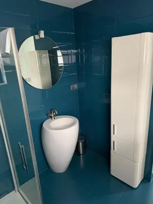 a blue bathroom with a sink and a mirror at Luxury Prague House in Herink