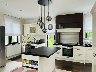 a kitchen with white cabinets and a black counter top at Luxury Prague House in Herink