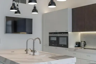 a white kitchen with a sink and a counter at Luxury Old Town Penthouse w park in Prague