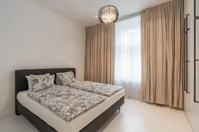 a bedroom with a bed and a large window at Luxury Old Town Penthouse w park in Prague