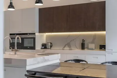 a kitchen with a sink and a counter with chairs at Luxury Old Town Penthouse w park in Prague