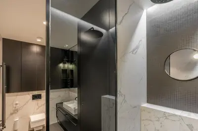 a bathroom with a shower with a sink and a mirror at Luxury Old Town Penthouse w park in Prague