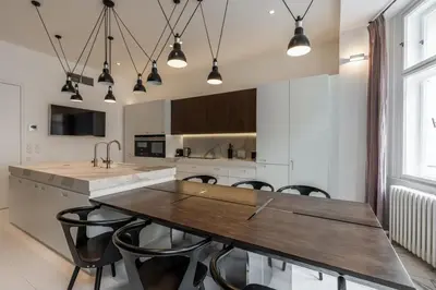 a kitchen with a wooden table and chairs at Luxury Old Town Penthouse w park in Prague
