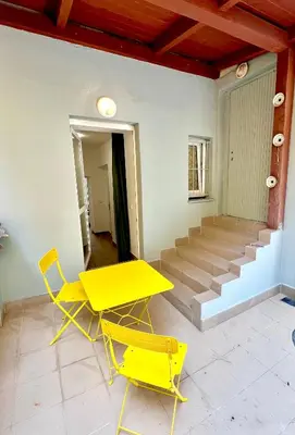 a yellow table and chairs in a room with stairs at Holeckova125 in Prague