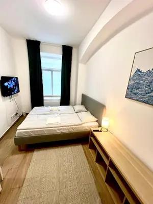 a small bedroom with a bed and a window at Holeckova125 in Prague